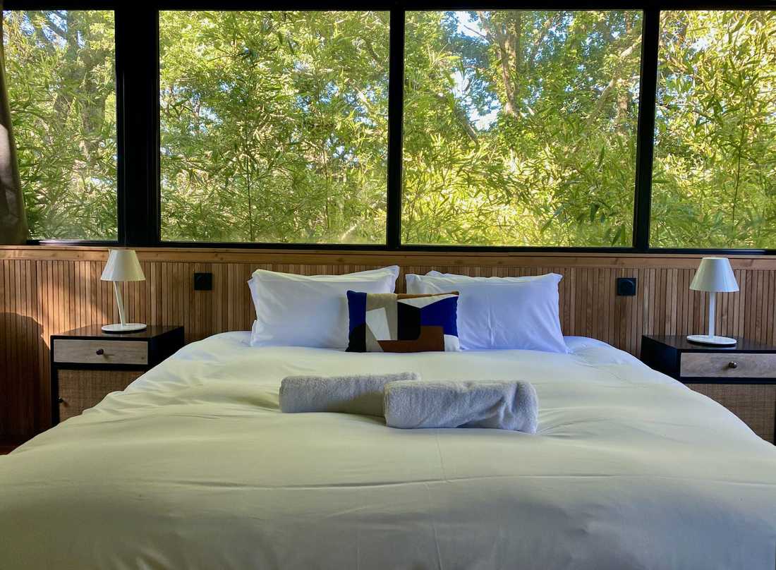 Aménagement d'un hôtel 4 étoiles ecolodge - chambre avec lit avec vue sur la végétation