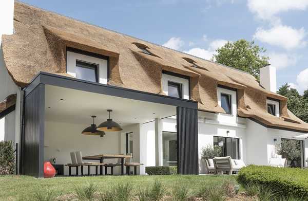 Un architecte d’intérieur et un paysagiste aménage la terrase, la pool house et la piscine à débordement d'une ville à Bruxelles.