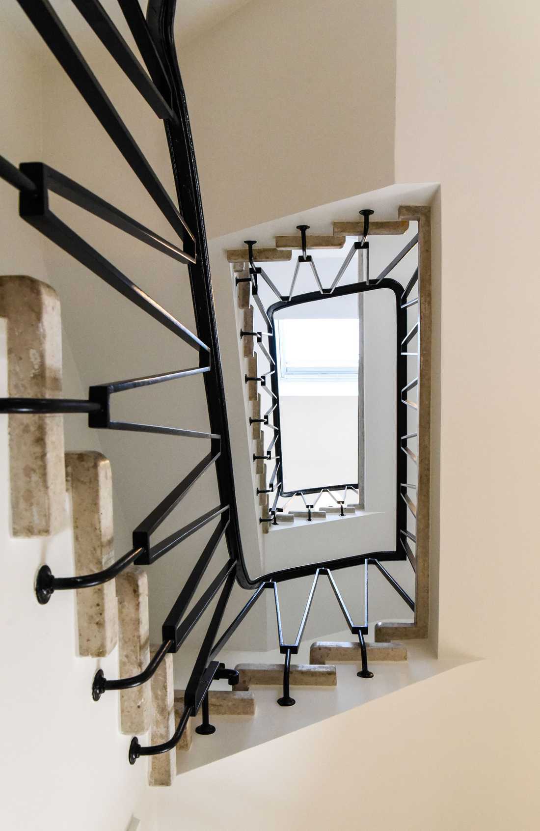 Escalier d’origine, avec marches en granito et  main courante en acier laqué noir